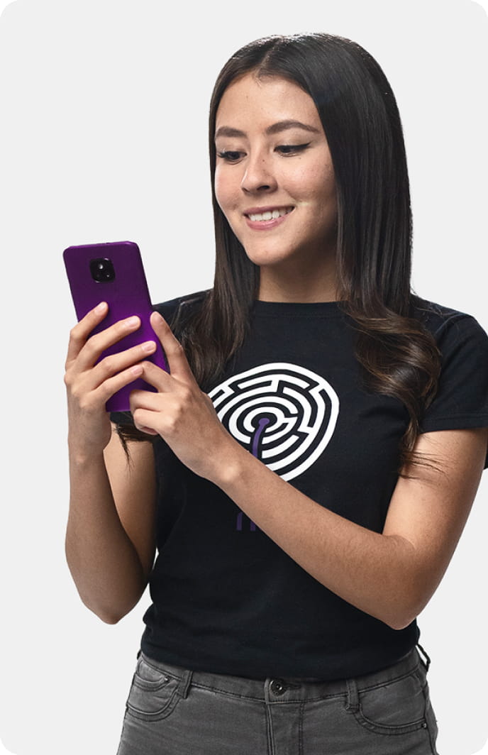 Una persona sonrie mientras sostiene su telefono morado en la mano